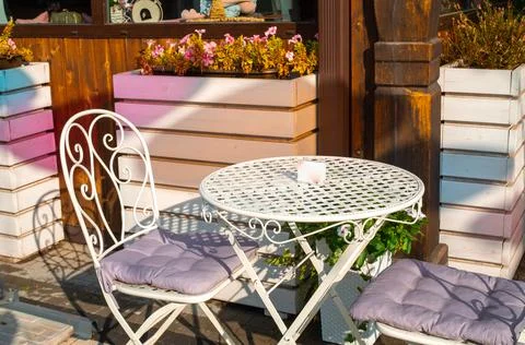 Empty white table and couple chairs on street outside a cafe bar or restaurant Stock Photos