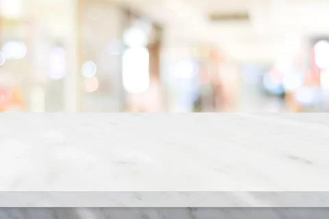 Empty white table top, counter, desk over blur perspective store with bokeh l Stock Photos