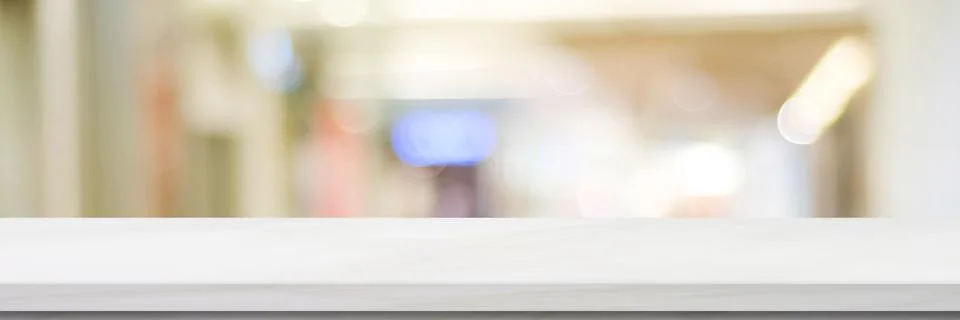 Empty white table top, counter, desk over blur perspective store with bokeh l Stock Photos
