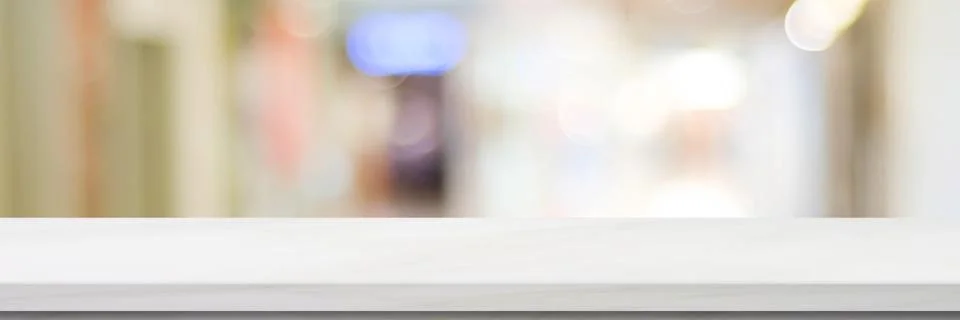 Empty white table top, counter, desk over blur perspective store with bokeh l Stock Photos