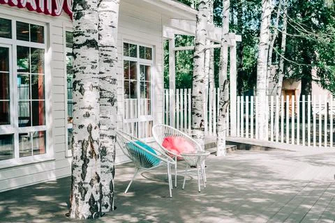 Empty white tables outside restaurant cafe. Chair with colored pillows on Stock Photos