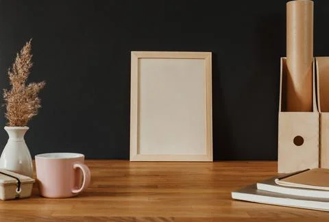 Empty white vertical frame on wooden desk Stock Photos