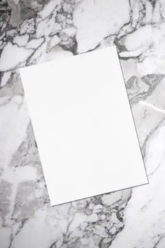 Empty white vertical rectangle poster or card mockup lying diagonally on grey Stock Photos