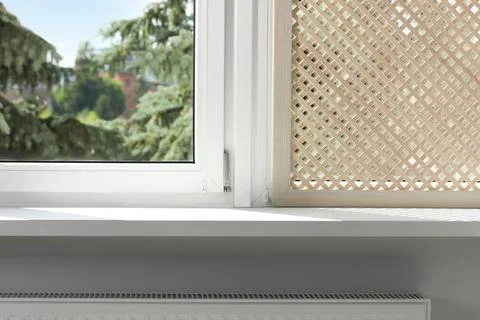 Empty white window sill and decorative wooden shutter indoors Stock Photos