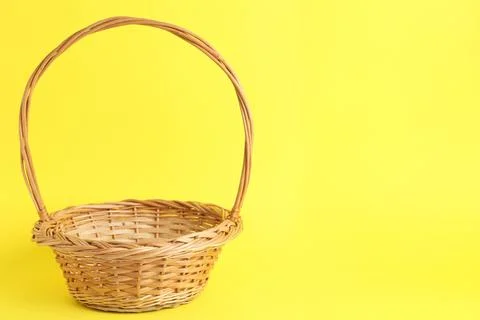 Empty wicker basket on color background, space for text. Easter item Stock Photos