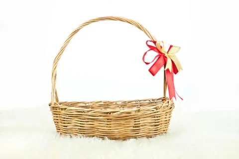 Empty wicker basket with red and gold ribbon isolated on white background Stock Photos