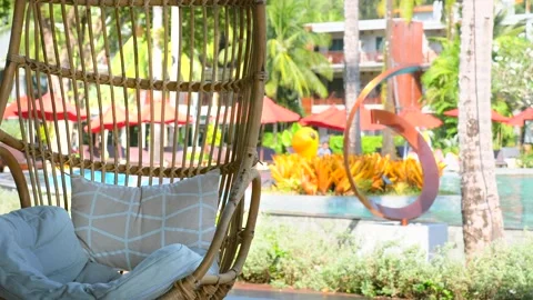 Empty wicker rattan swing chair swaying, tourist, travel, holiday, vacations Видео 183883450