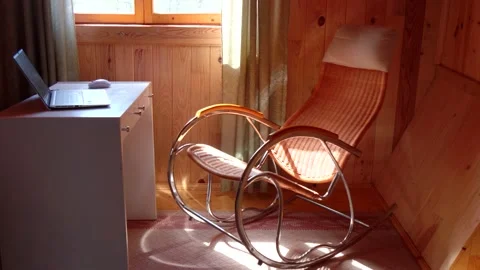 An empty wicker rocking chair made of wood sways in the sun in a country hous Stock Footage 152568889