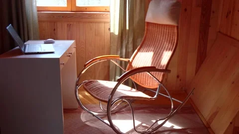An empty wicker rocking chair made of wood sways in the sun in a country hous Stock Footage 152568950