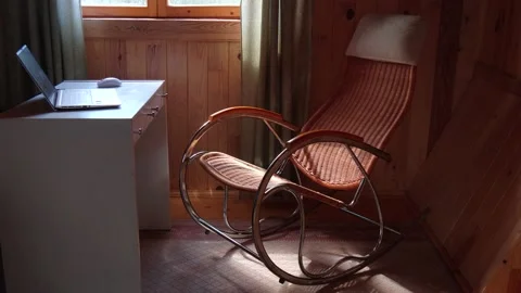 An empty wicker rocking chair made of wood sways in the sun in a country hous Stock Footage 152570366