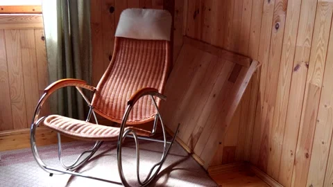 An empty wicker rocking chair made of wood sways in the sun in a country house Stock Footage 152574688