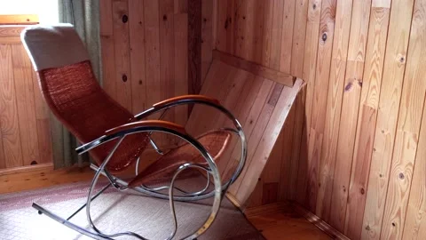 An empty wicker rocking chair made of wood sways in the sun in a country hous Stock Footage 152575911