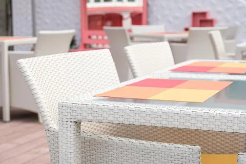 Empty wicker table with glass top and plastic wicker chair Stock Photos