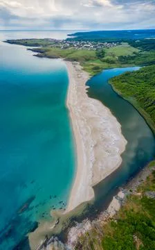 An empty wild beach, surrounded by rocks and green thick forests 스톡 사진