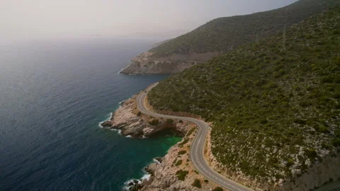 An empty winding road along the sea. Drone shot 4k Stock Footage 254776054