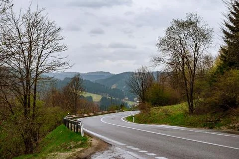 Empty winding road through forests in mountains. Stock Photos