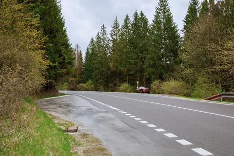Empty winding road through forests in mountains. Stock Photos