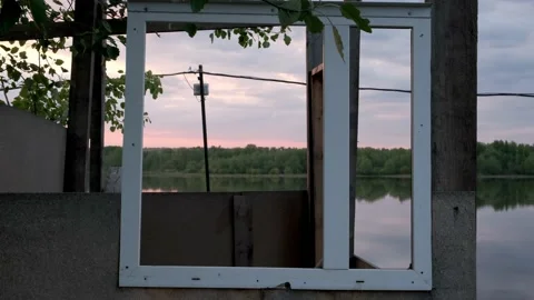 An empty window frame looks out over the river Stock Footage 196822149