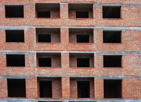 Empty windows in brick multistory house under construction Stock-Fotos