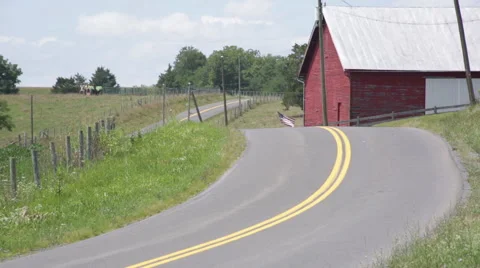 Empty windy country road with barn Stock Footage 66501094