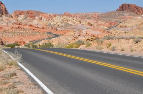 Empty windy two lane road in the desert. Stock Photos