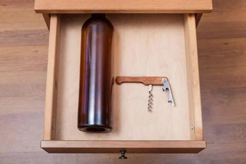 Empty wine bottle and corkscrew in open drawer top view of empty wine bott... Stock Photos