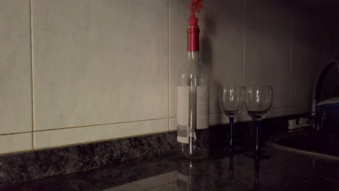 Empty wine bottle and wine glass in the kitchen Stock Footage