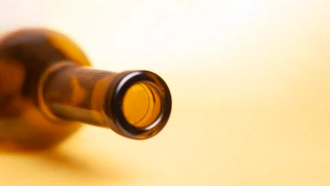 Empty wine bottle on a yellow background closeup. Stock Photos