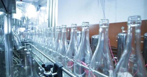 Empty wine glass bottles approaching in line for cleaning and filling process 動画素材 94960903