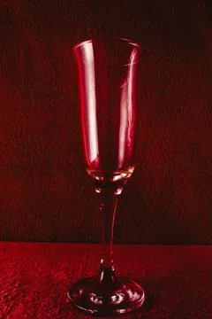 Empty wine glass on red background with side lighting. Stock Photos