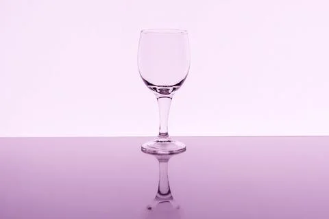 Empty wine glass with reflection on background, toned Foto stock