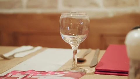 Empty wine glass on a table in a fancy restaurant, cinematic 4K video Stock Footage 263931628