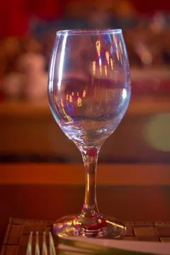 Empty wine glass. Tableware on table in cafe, focus on wineglass stem . Elega Stock Photos