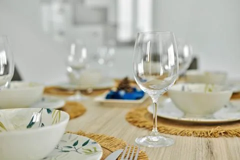 Empty wine glasses and dinnerware served on dining table Stock Photos