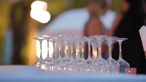 Empty wine glasses awaiting guests at outdoor evening event Stock Footage 310717432