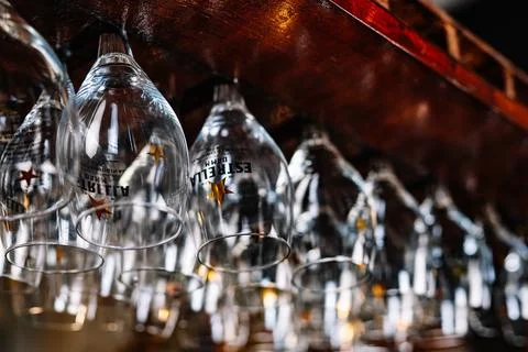 Empty wine glasses hanging on rack in pub bar Stock Photos