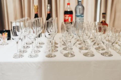 Empty wine glasses line a white-clothed table Foto stock
