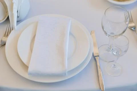 Empty wine glasses on a round table with a white tablecloth. Foto stock
