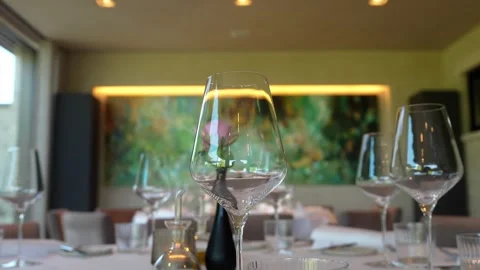 Empty wine glasses standing on table with blurry background inside luxurious Stock Footage 335387869