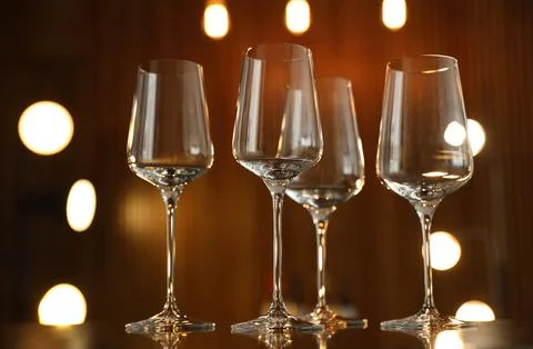 Empty wine glasses on table against blurred background Stock Photos