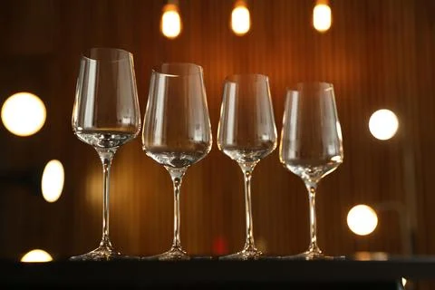Empty wine glasses on table against blurred background Stock Photos