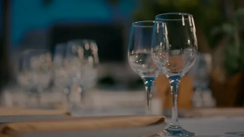 Empty wine glasses on the table in the garden in the evening. Stock Footage 240949519