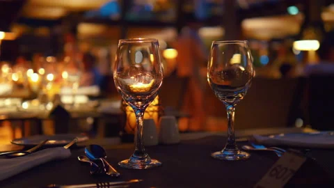Empty wine glasses on a table in a restaurant at night in 4k slow motion 60fps 스톡 동영상 105059596