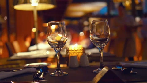 Empty wine glasses on a table in a restaurant at night in 4k slow motion 60fps Video stock 105060088