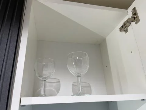 Empty wine glasses in a white cupboard, closeup of photo Stock Photos