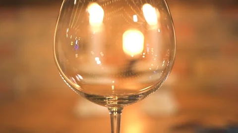 Empty wineglass on burning candles background. Close up wine glass on evening Stock Footage 103444452