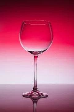 Empty wineglass for red wine on diffusion lit background in abstract composit Foto stock