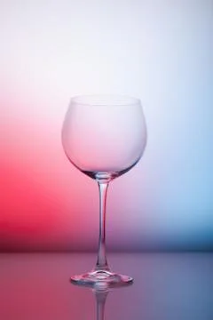 Empty wineglass for red wine on diffusion lit background in abstract composit Foto stock