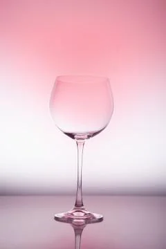 Empty wineglass for red wine on diffusion lit background in abstract composit Foto stock