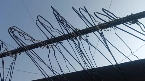 Empty Wire Hangers Gently Swaying on Outdoor Rack - Static Shot Stock Footage 341993388